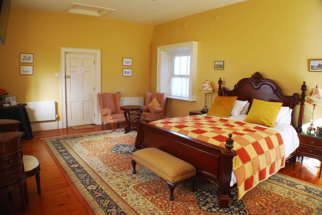 Chambord Suite bedroom at Clonganny House Wexford — warm terracotta tones and elegant vintage furnishings