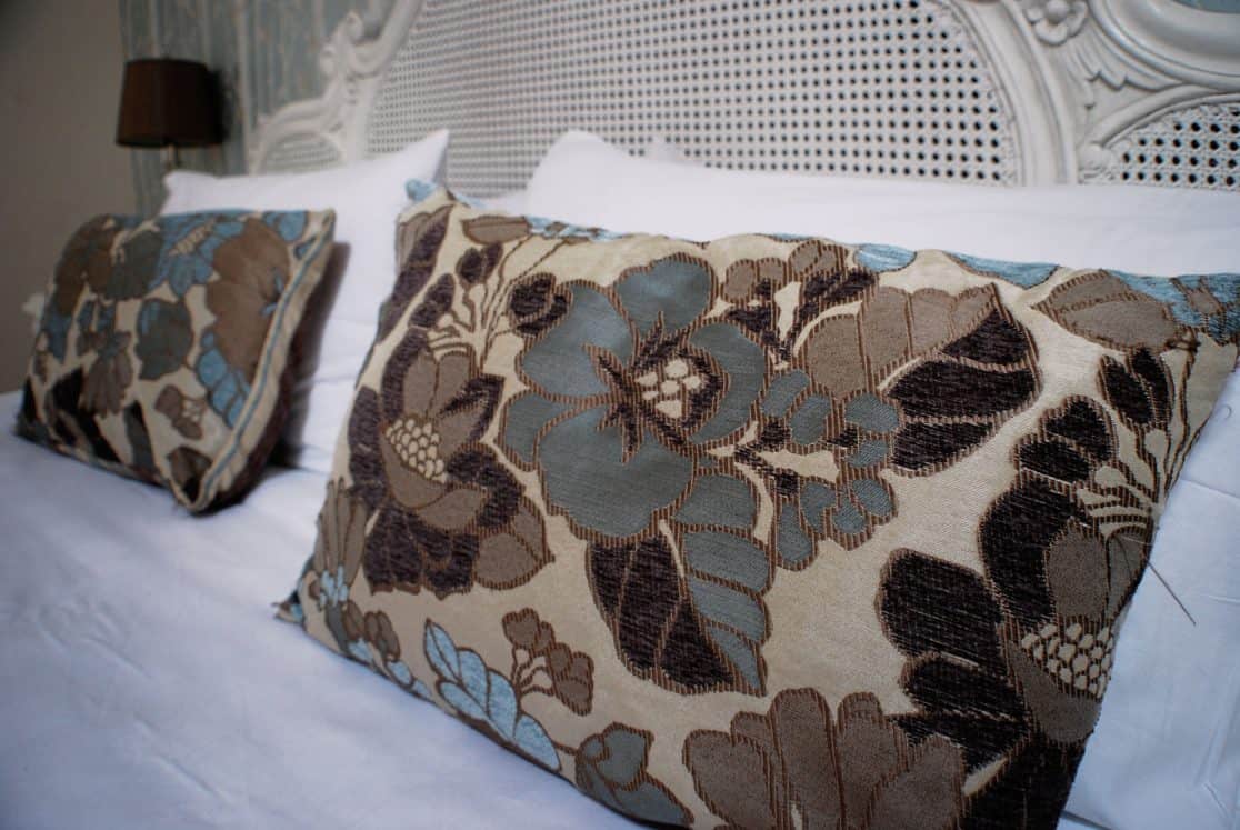 Chaumont Suite at Clonganny House Wexford — beautifully carved bed with rattan insets and floral cushion