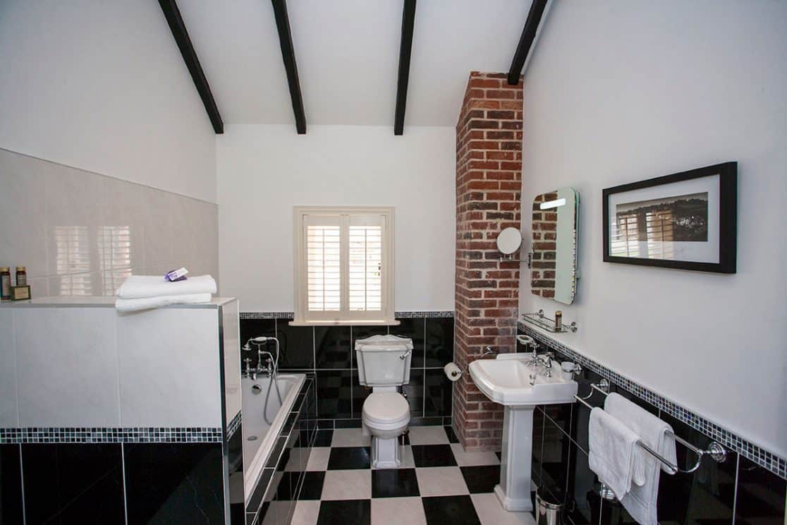 Cheverney Suite bathroom at Clonganny House Wexford — classic black and white tiles with mosaic insets, bath and separate shower