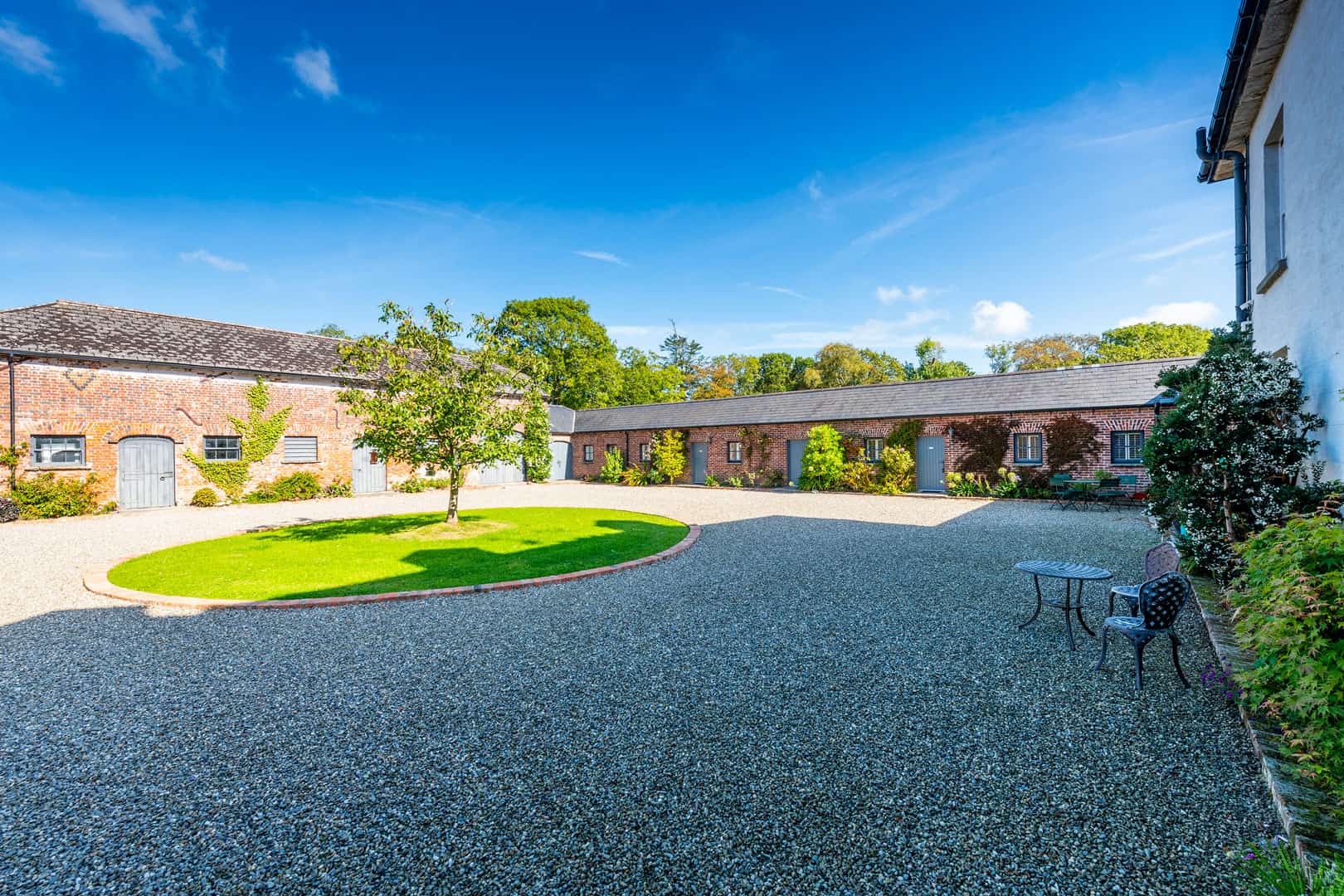 Clonganny House walled courtyard with lush greenery and stone buildings, Co. Wexford, Ireland